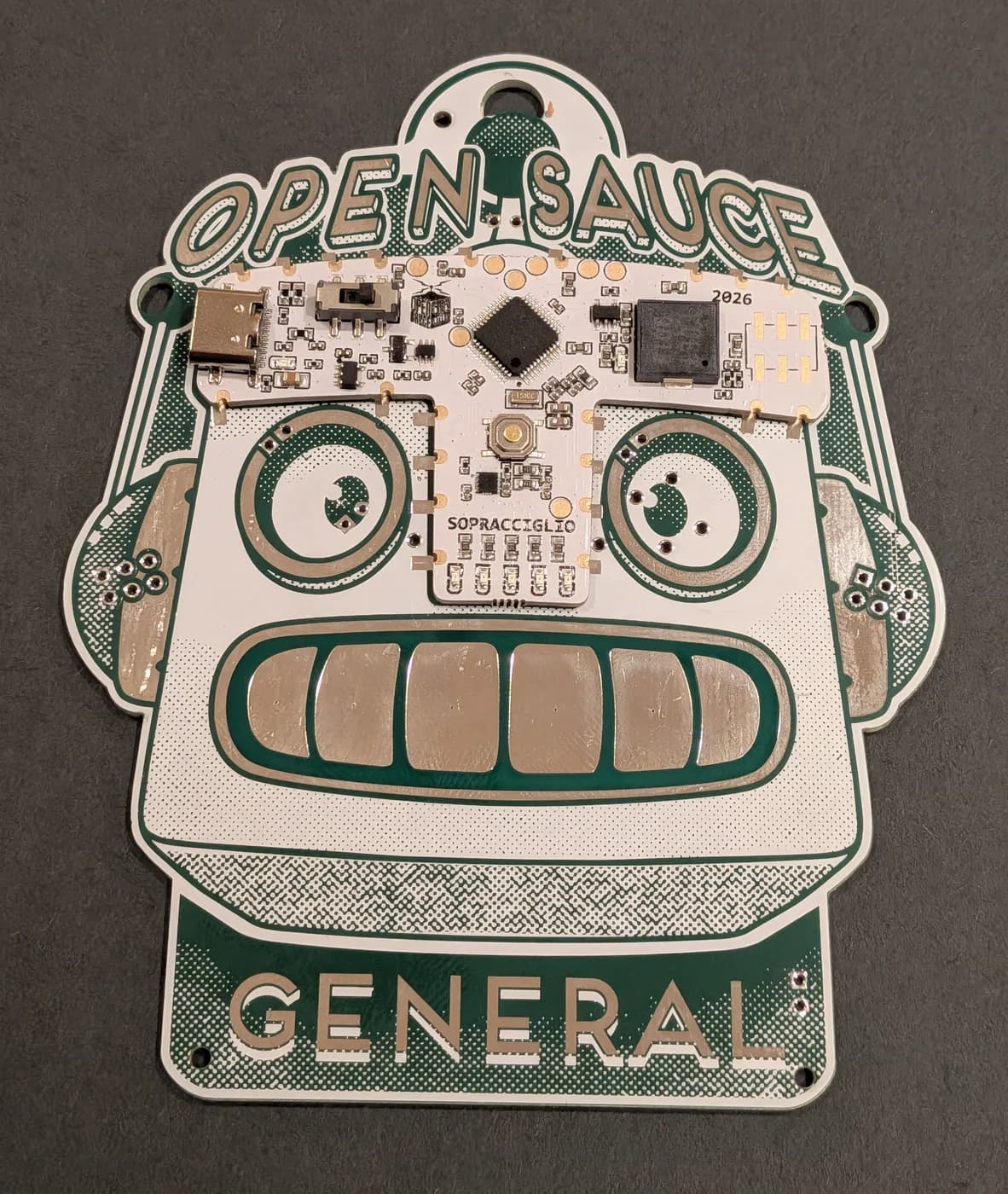 The T-piece aligned on the badge, gold edge pads sitting over the silver badge pads