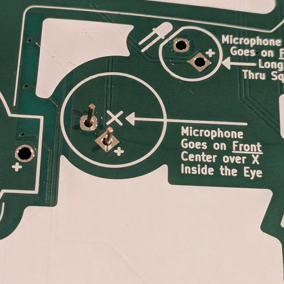 Back of the badge with both microphone leads poking through the holes
