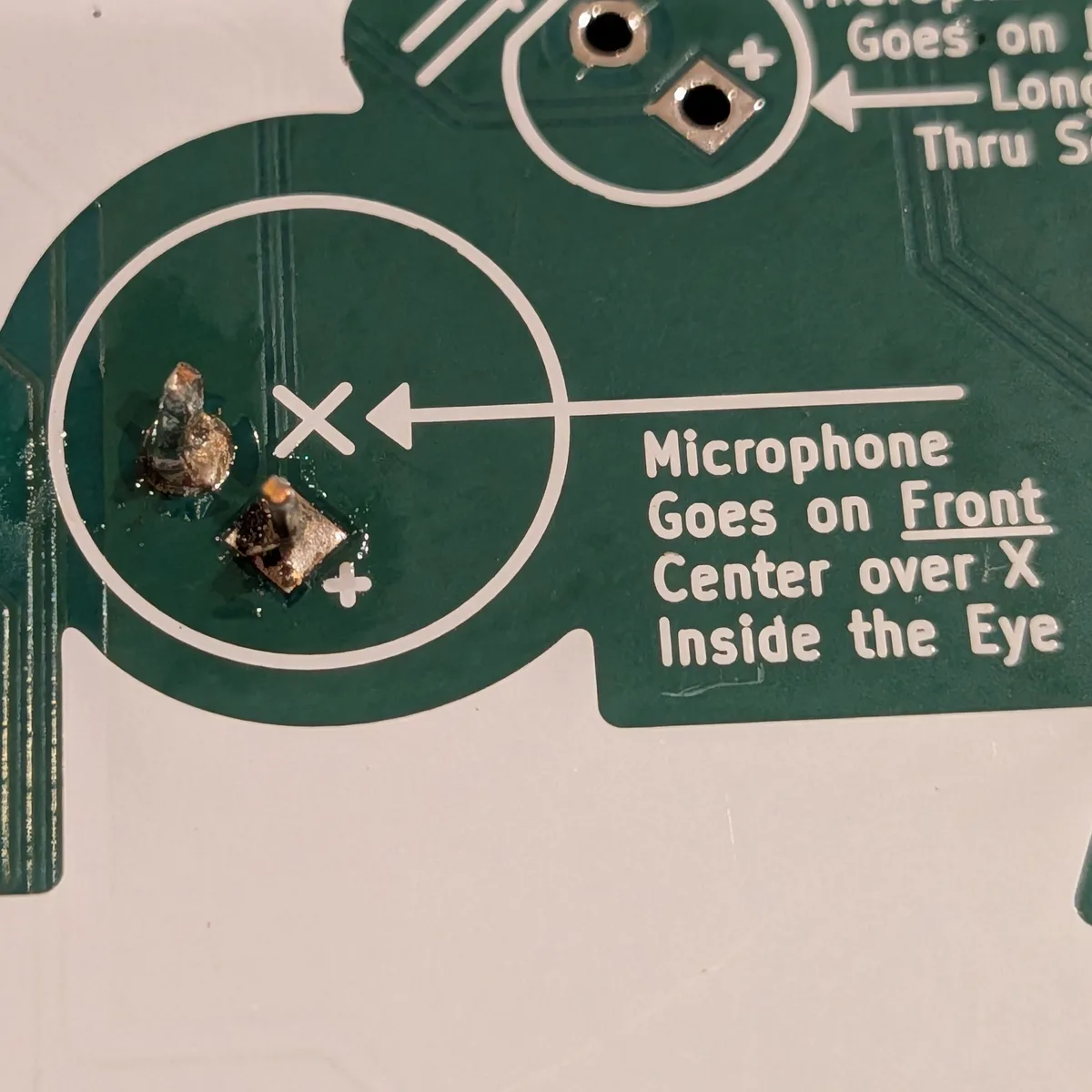 Microphone leads soldered on the back of the badge
