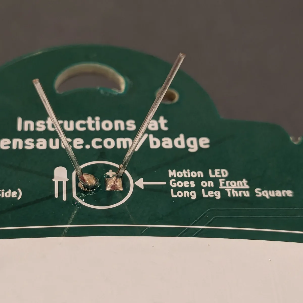 LED leads bent outward and soldered on the back of the badge